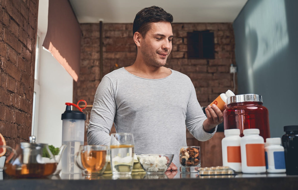 Fit man examining a dietary supplement in his hand